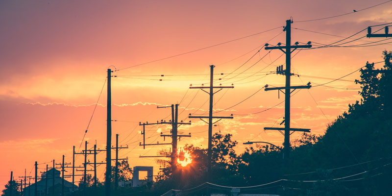 power poles and power lines during sunset