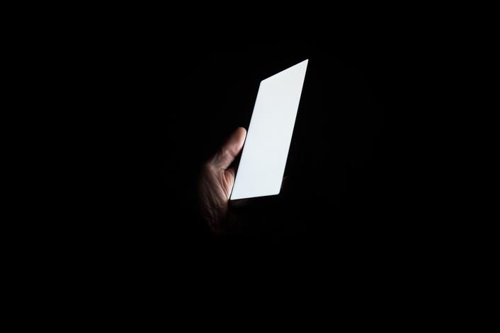 person using smartphone during power outage for emergency