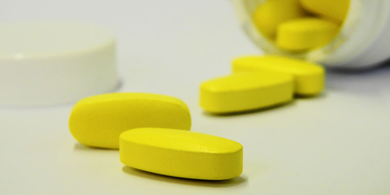 yellow pills and pill bottle
